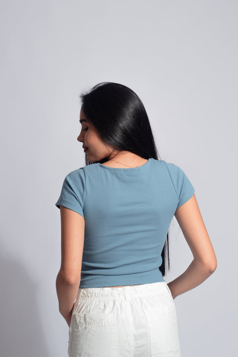 Polo básico con botones en color denim, encarnando un estilo joven, casual y minimalista.