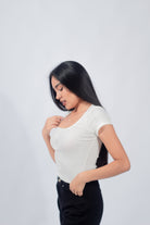Polo básico con botones en un suave tono ivory, reflejando un estilo casual y minimalista para mujeres jóvenes