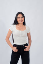 Polo básico con botones en un suave tono ivory, reflejando un estilo casual y minimalista para mujeres jóvenes