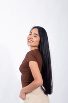 Polo básico con botones en tono marrón, reflejando un estilo casual y minimalista para mujeres jóvenes.