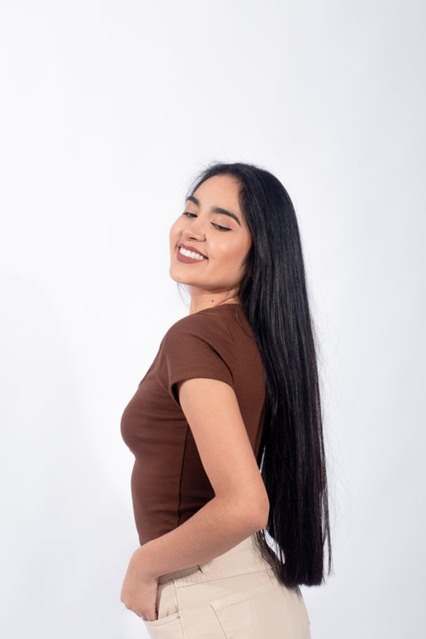Polo básico con botones en tono marrón, reflejando un estilo casual y minimalista para mujeres jóvenes.